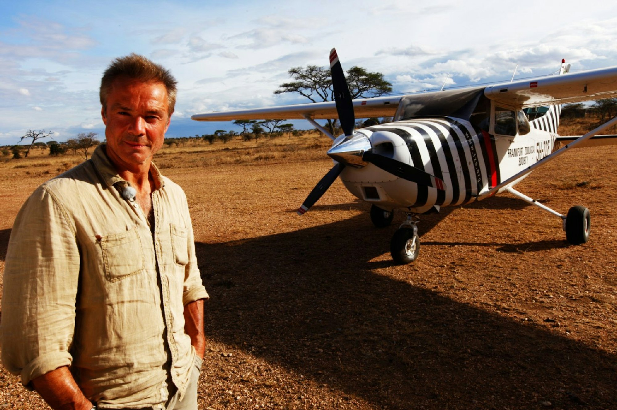 Jaenicke steht vor dem berühmten „geflügelten Zebra“ – dem Flugzeug von Bernhard Grzimek.