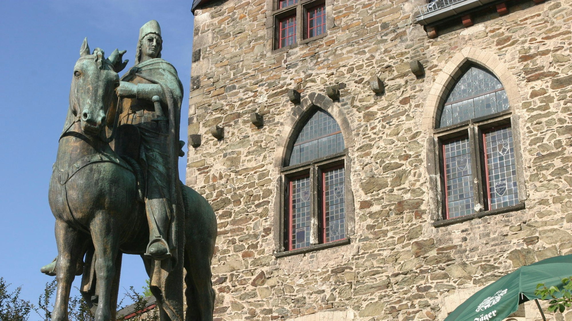 Eine Statur von Engelbert von Berg sitzt auf dem Pferd vor Schloss Burg.