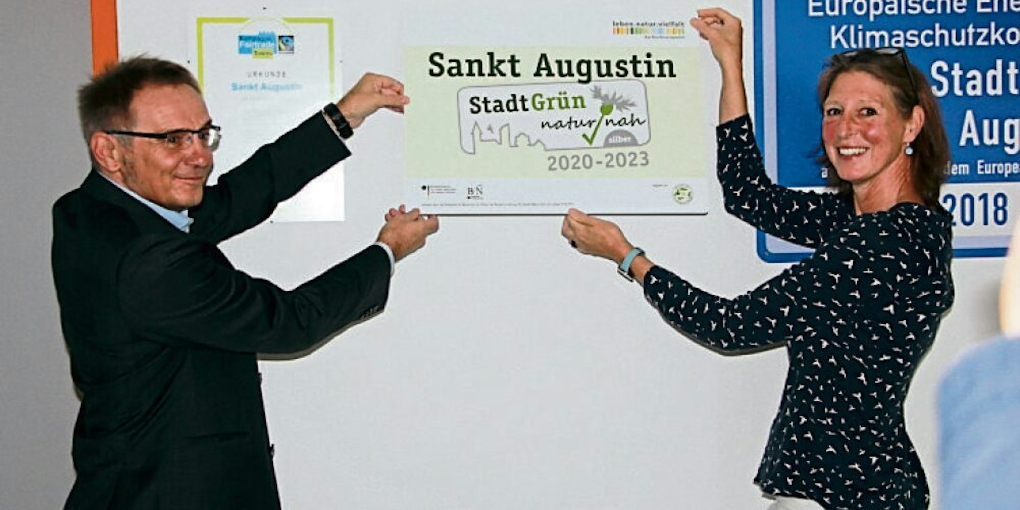 Das Label „Stadt-Grün“ hängten der Beigeordnete Rainer Gleß und Sandra Paul vom Umwelt- und Naturschutzbüro im Rathaus auf.
