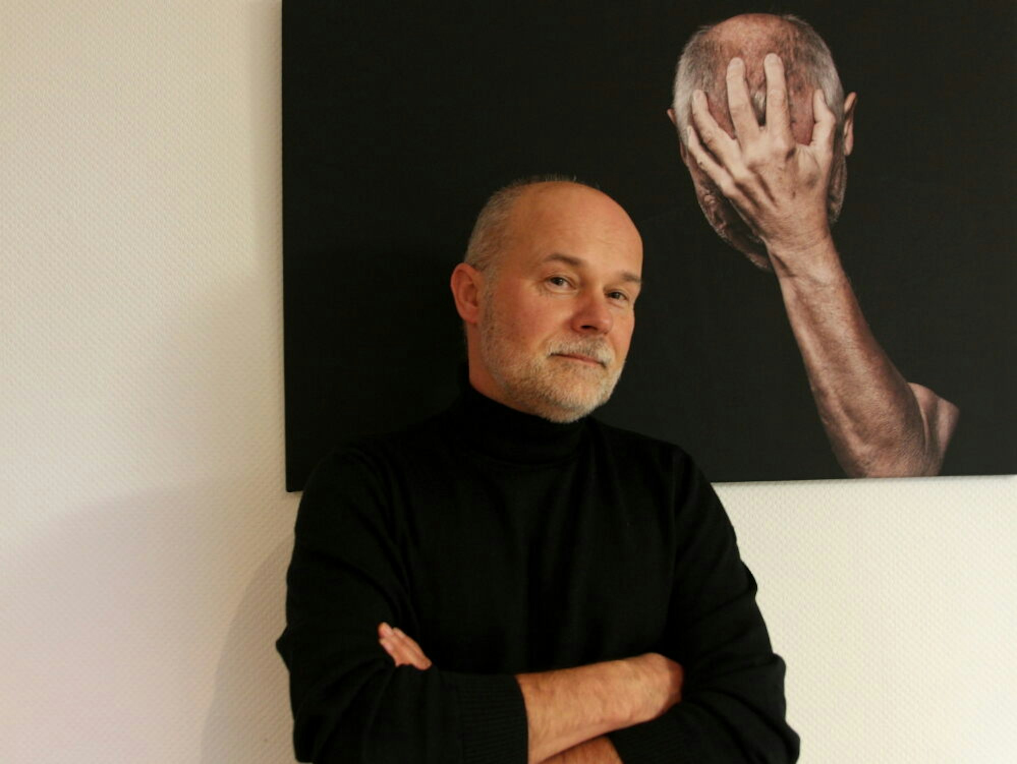 Fotograf Manfred Jasmund vor einem Selbstporträt.
