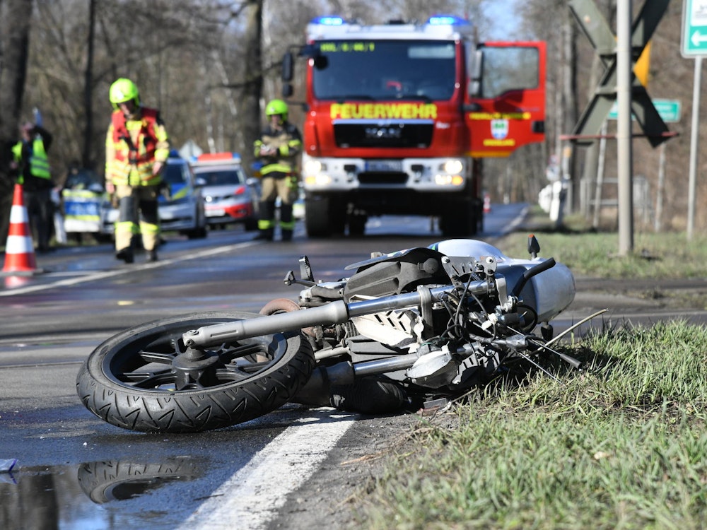 Ein stark beschädigtes Motorrad liegt auf einer Landstraße.