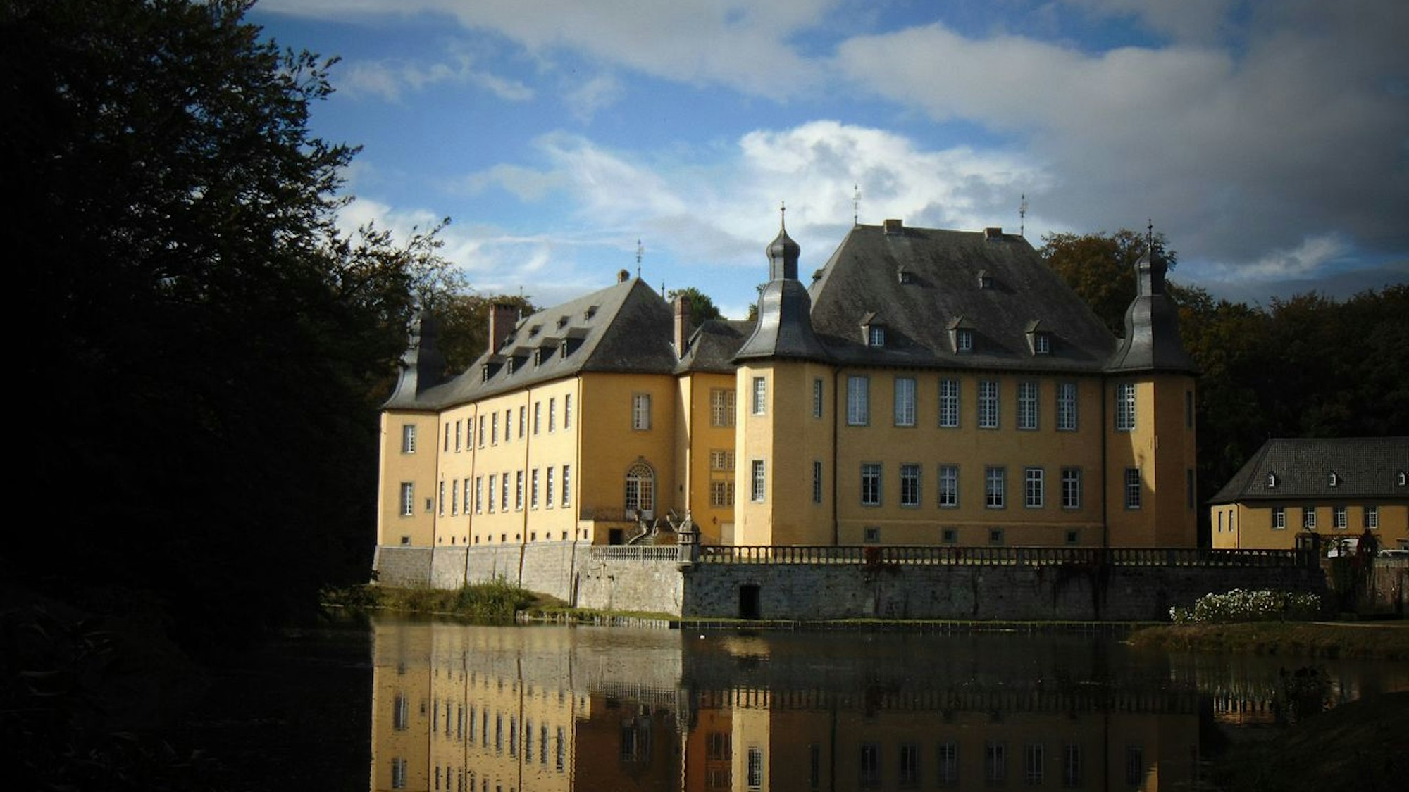 gelbes Schloss vor einem Wassergraben