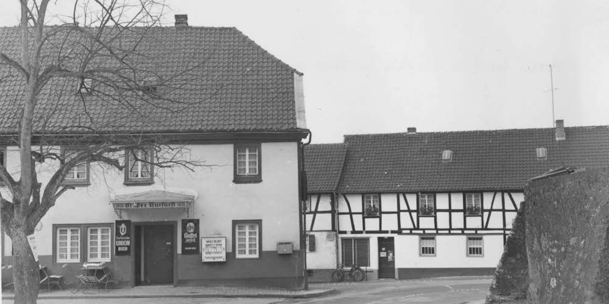 Die Gaststätte „Großer Kurfürst“ ist links zu sehen, rechts die Kirchhofmauer, geradeaus die Einmündung (Alte) Dellbrücker Straße.
