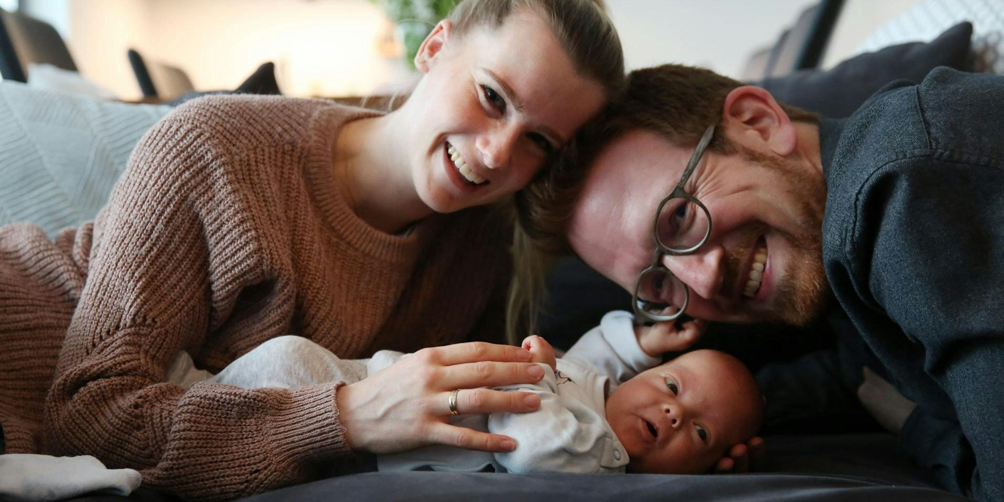 Eva und Max Wenner kuscheln mit Sohn Linus.