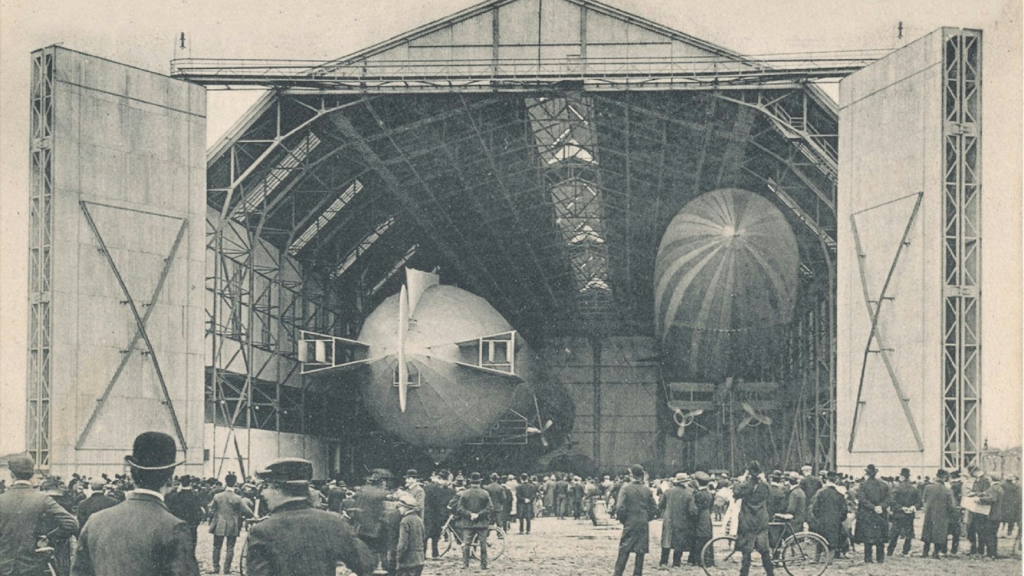Etliche Schaulustige bestaunen zwei Zeppeline, die in der Bickendorfer Luftschiffhalle parken.