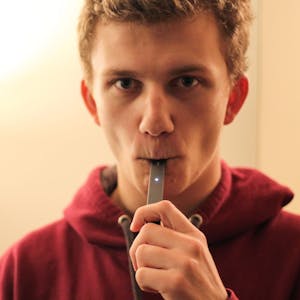 Der Student Nathan Behr raucht eine E-Zigarette der Marke Juul.