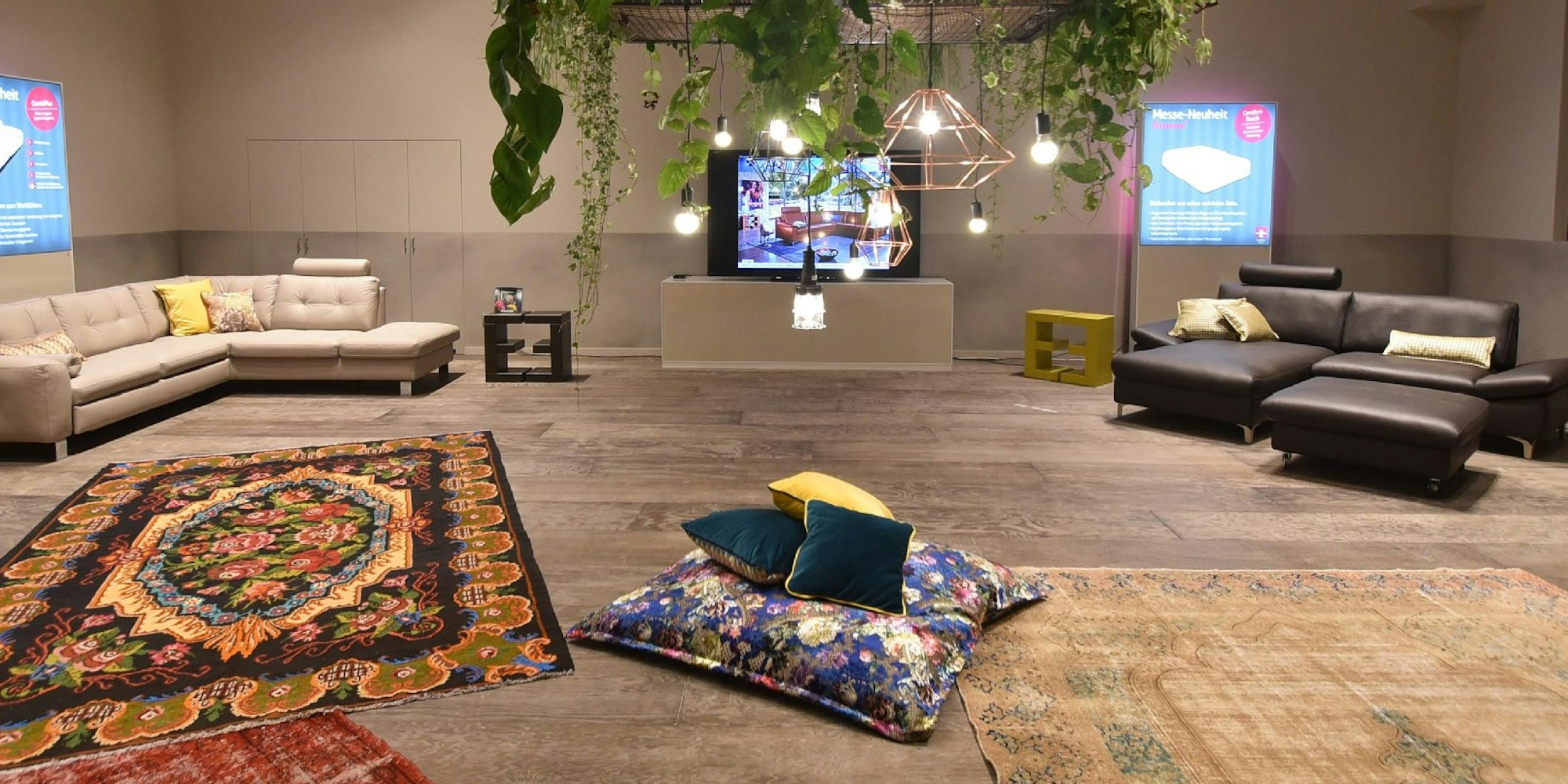 Großzügige Wohnwelten mit bunten Teppichen und Kissen, die Akzente setzen - so stellt sich Hersteller Ewald Schillig das zeitgemäße Heim vor.