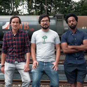 Drei Kölner Start-up-Unternehmer: Thomas Chiang, Kalie Cheng und Abiye Dagnew vor den Müllzügen der AWB