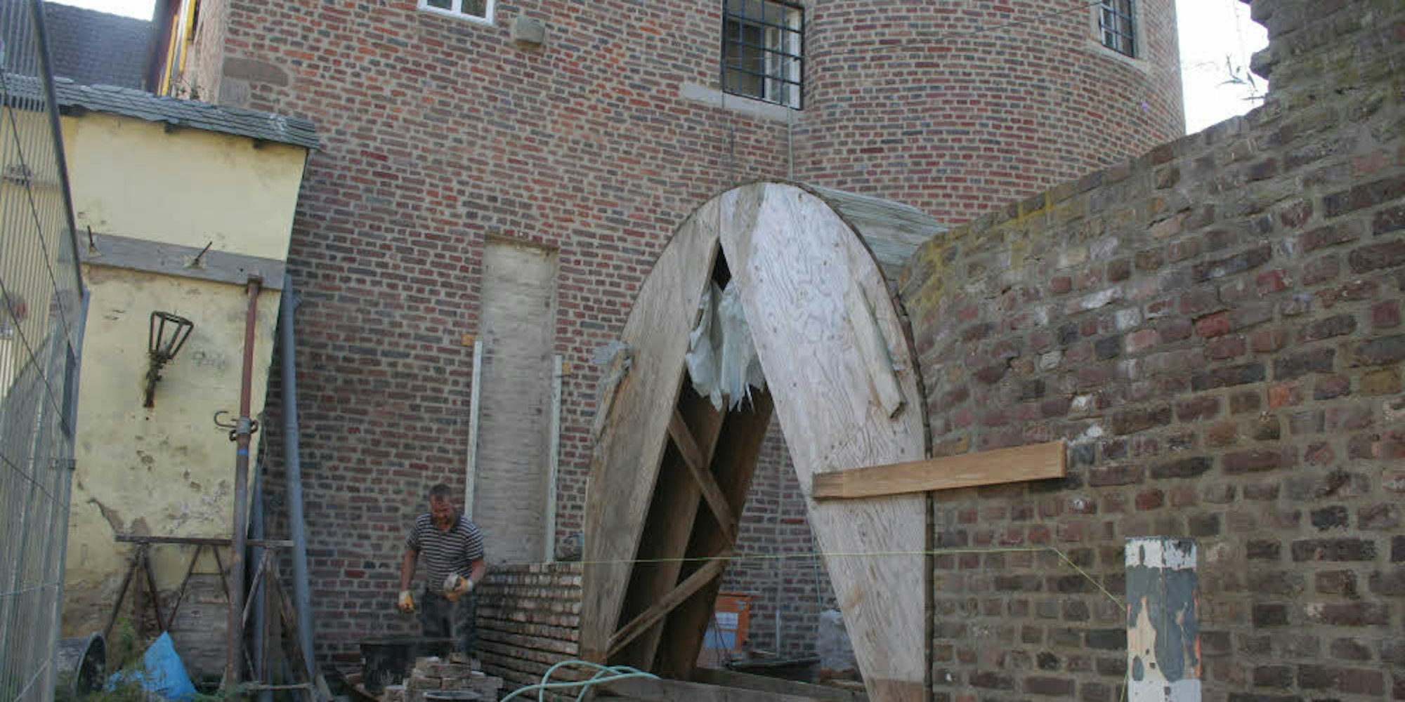 Eine Schablone aus Holz hilft dabei, den Torbogen neben dem Aachener Tor in der gleichen Größe wieder aufzubauen wie seinen Vorgänger.
