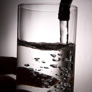 Ein Glas Wasser auf dem Wasserhahn