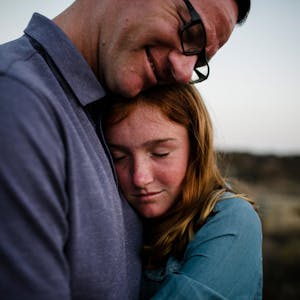 Ein Vater und seine Tochter nehmen sich in den Arm.
