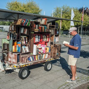 Einfach zugreifen: Dieser Bücherwagen steht im Neulandpark auf Rädern und wurde von einem Künstler gebaut. Wer will, kann schmökern und sich einfach bedienen. Unsere Autorin hat sich in Leverkusen mal umgeschaut, was die Bücherschränke so bieten.