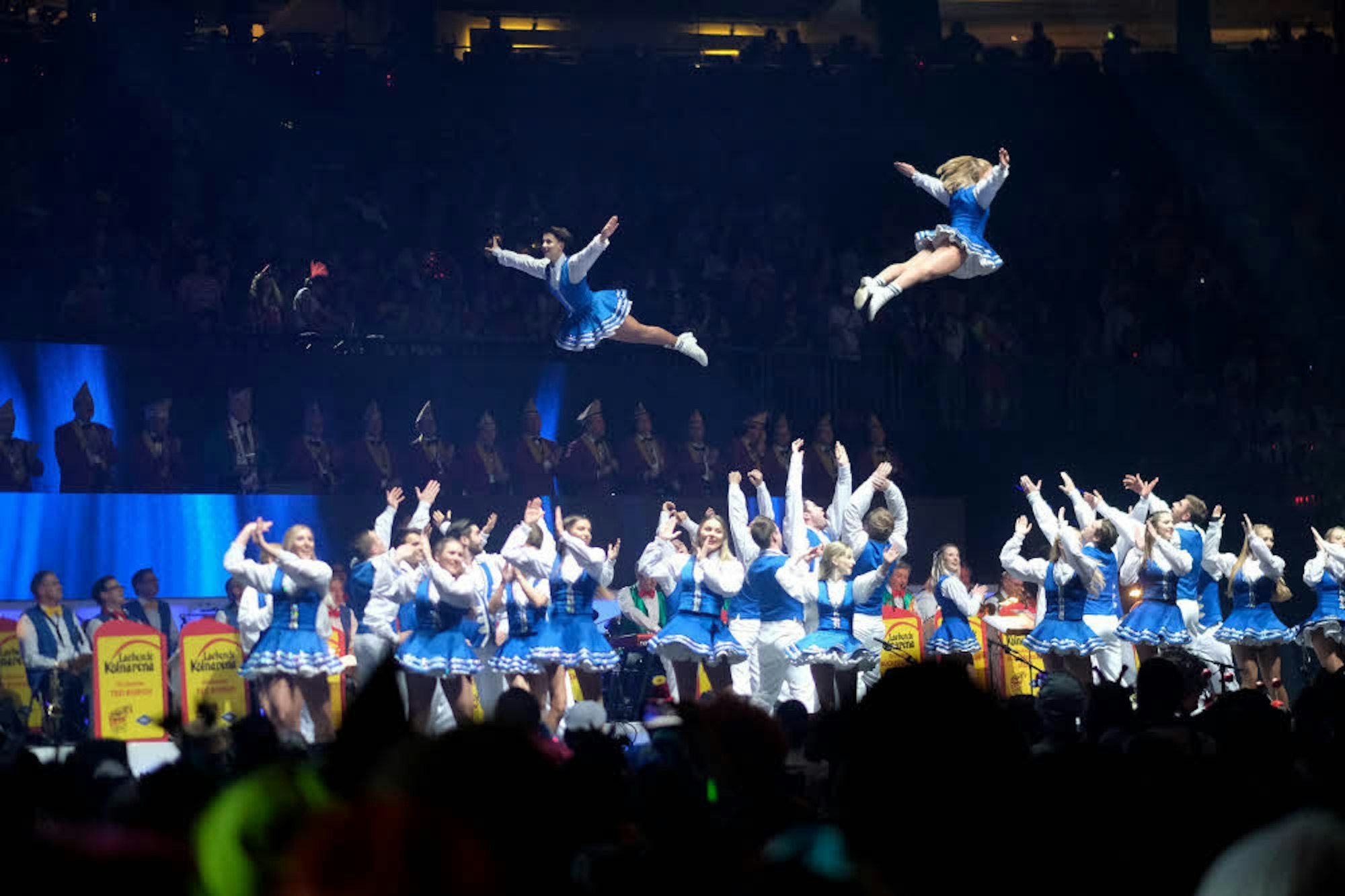 Die fliegenden Tänzerinnen der „Luftflotte“ begeistern auch den Elferrat (im Hintergrund).