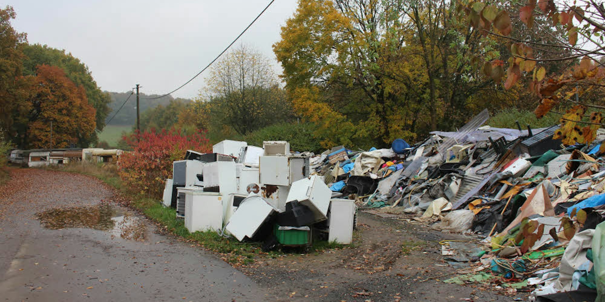 Ausgeschlachtete Campingwagen, alte Kühlschränke und anderer Müll warten derzeit auf der Stadtgrenze von Overath und Lohmar auf ihre umweltgerechte Entsorgung.