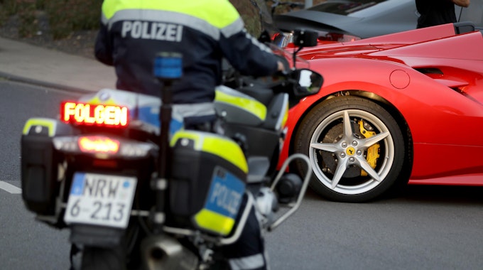 Ein Motorradpolizist hat einen Ferrari angehalten.