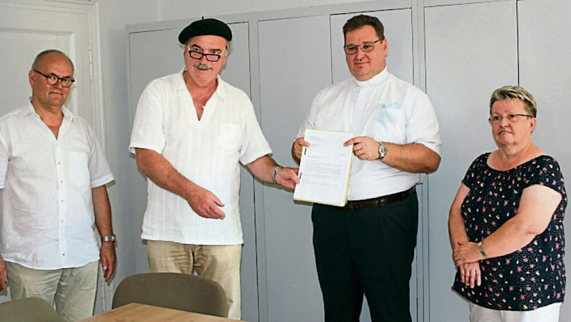 Eine Liste mit mehr als 400 Unterschriften übergaben (v.l.) Martin Pfeifer und Paul Hüsson an Pater Mikrut, rechts Marianne Bourauel vom Pfarrgemeinderat.