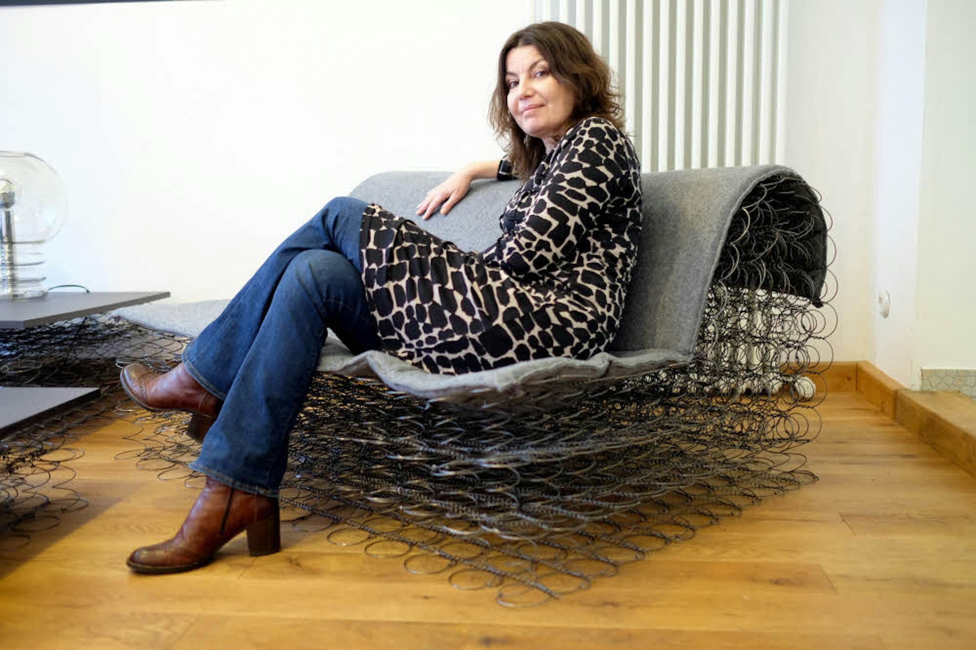 Patrizia Ricci auf einem lediglich aus Sprungfedern bestehenden Sofa der Möbelserie „The Minimalists“.