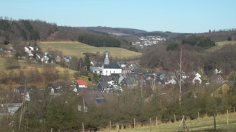 Blick auf kleines Tal mit Wohnhäusern und einer Kirche