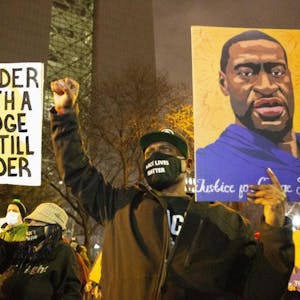 Während einer Demonstration gegen Polizeigewalt in Minneapolis hält ein Mann ein Portrait von George Floyd in die Höhe.
