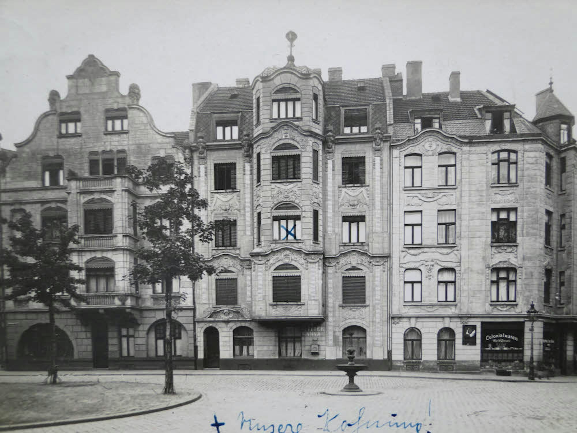Diese Postkarte zeigt die Fläche des heutigen „Schillplatzes“ um 1900 herum. Man beachte den Brunnen mitten auf der „Fahrbahn“.