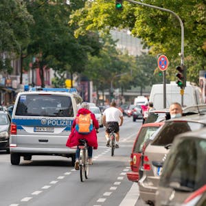 Auf der Hauptstraße sind viele Autos und Radfahrer unterwegs.