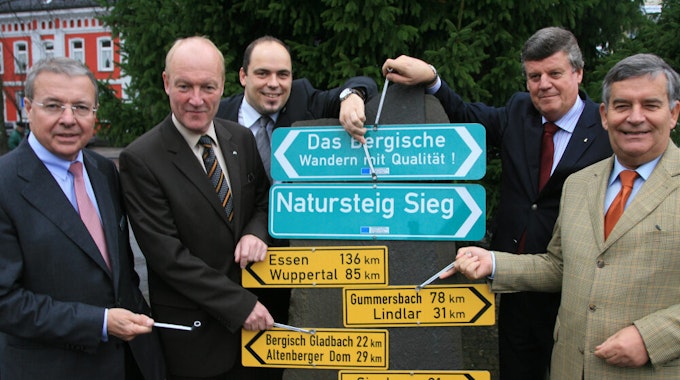 2009 übergibt Hans Peter Lindlar (2.v.r.) die Förderbescheide für Bergisches Wanderland und Natursteig Sieg in Overath an (v.l.) ​Landrat Frithjof Kühn (Rhein-Sieg), Landrat Rolf Menzel (Rhein-Berg), Mathias Derlin, Bürgermeister Andreas Heider, Landrat Hagen Jobi (Oberberg).