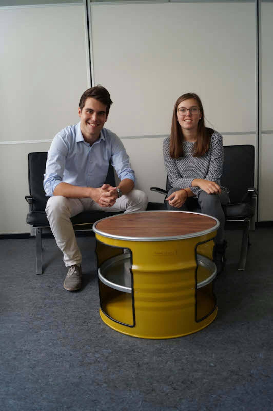 Katharina Siepe und Moritz Kinkel zeigen einen ihrer Tische, die sie aus Metallfässern fertigen.