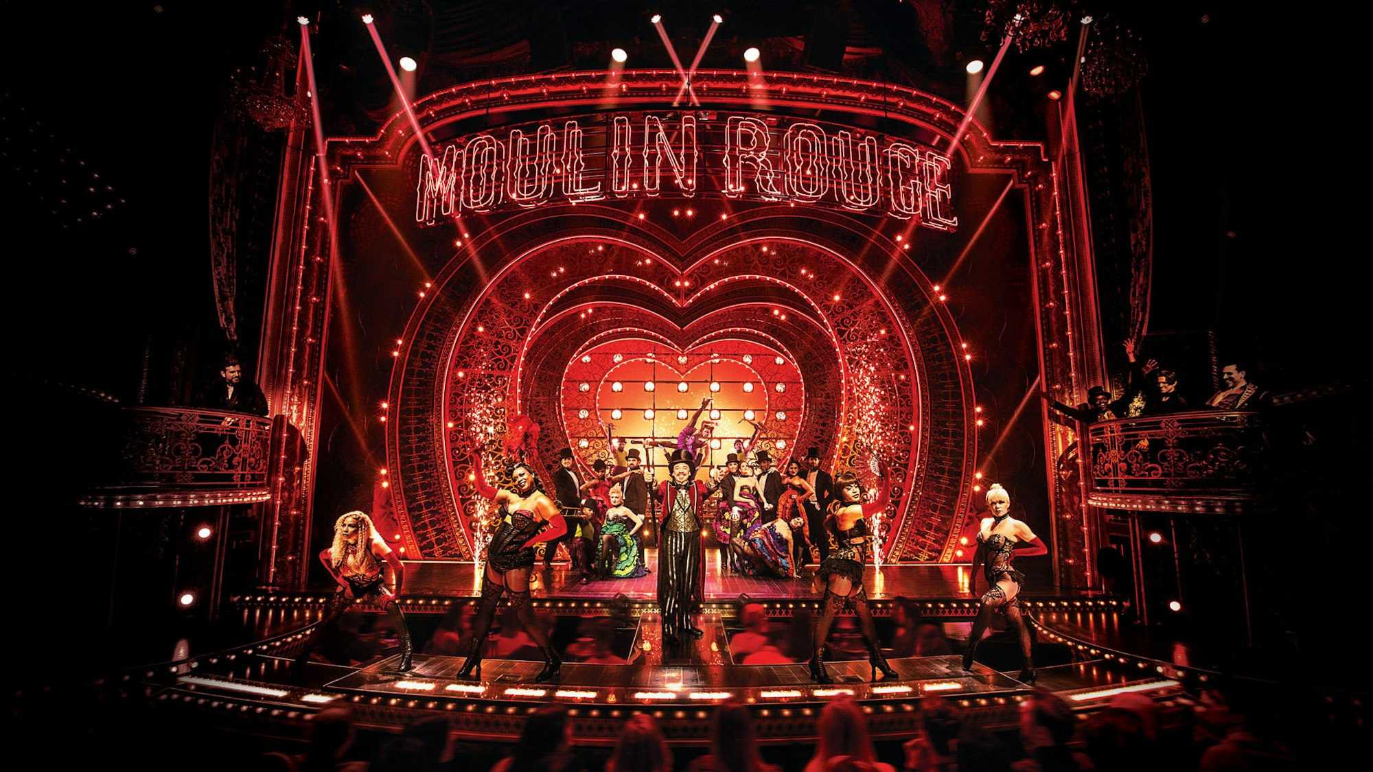 Die Bühne von Moulin Rouge mit viel Licht und allen Darstellern in Kostümen beim großen Finale.