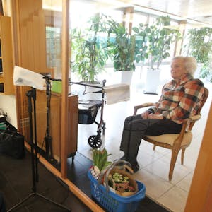 Eine Plexiglasscheibe trennt Thea Rensing (rechts) von ihren Töchtern Iris Rensing (links) und Petra Rink, die ihr zum 86. Geburtstag gratulierten. Geschützte Mikrofone übertragen die Stimmen aus der Kapelle in den Besuchsraum und zurück.