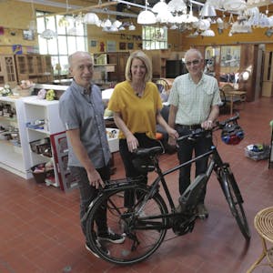 Auf die neuen E-Bikes für die Ökumenische Initiative warten Franz-Josef Beul (l.), Anne Loth und Dr. Herbert Sülz.