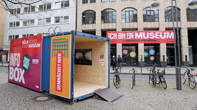 Mit einem Info-Container auf dem Kolpingplatz macht das Kölnische Stadtmuseum auf den kommenden Neustart im früheren Modehaus Franz Sauer aufmerksam.