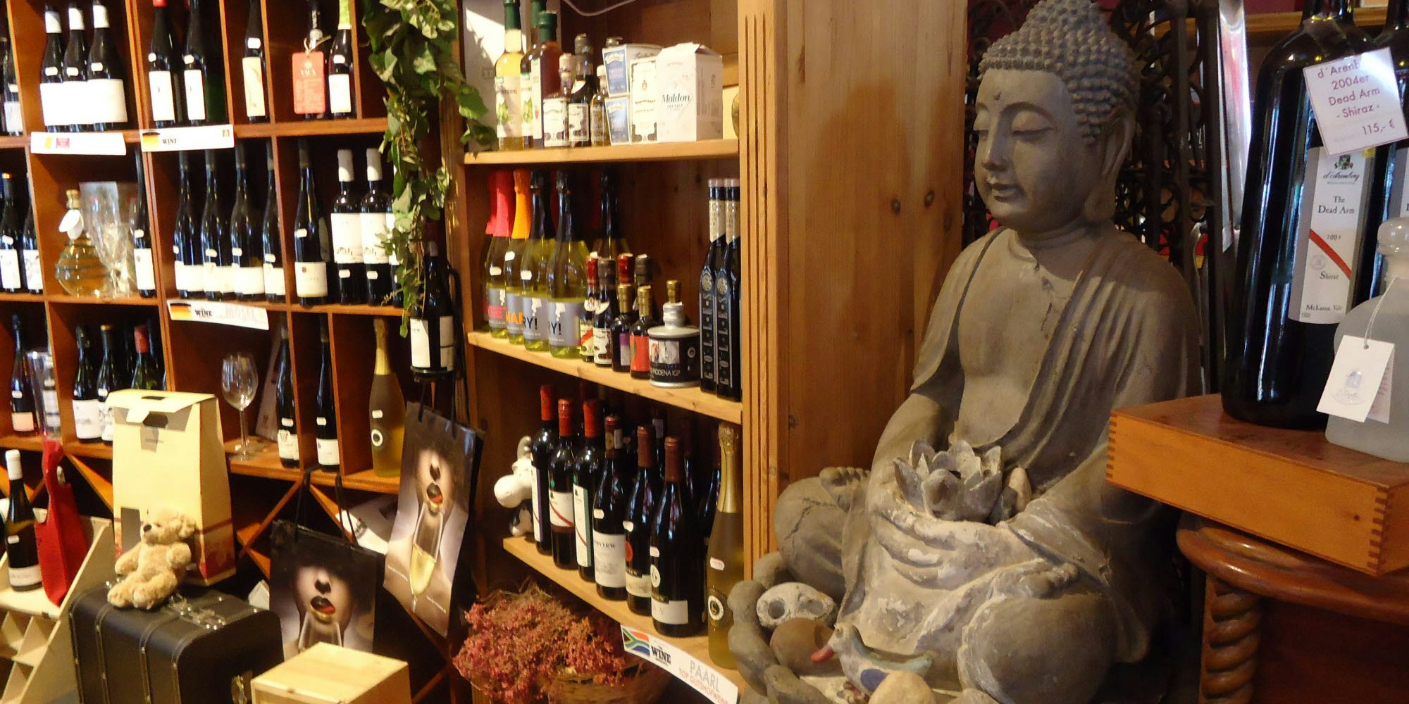 Ein Buddha inmitten des Weinsortiments, für das der Feinkostladen besonders bekannt war.