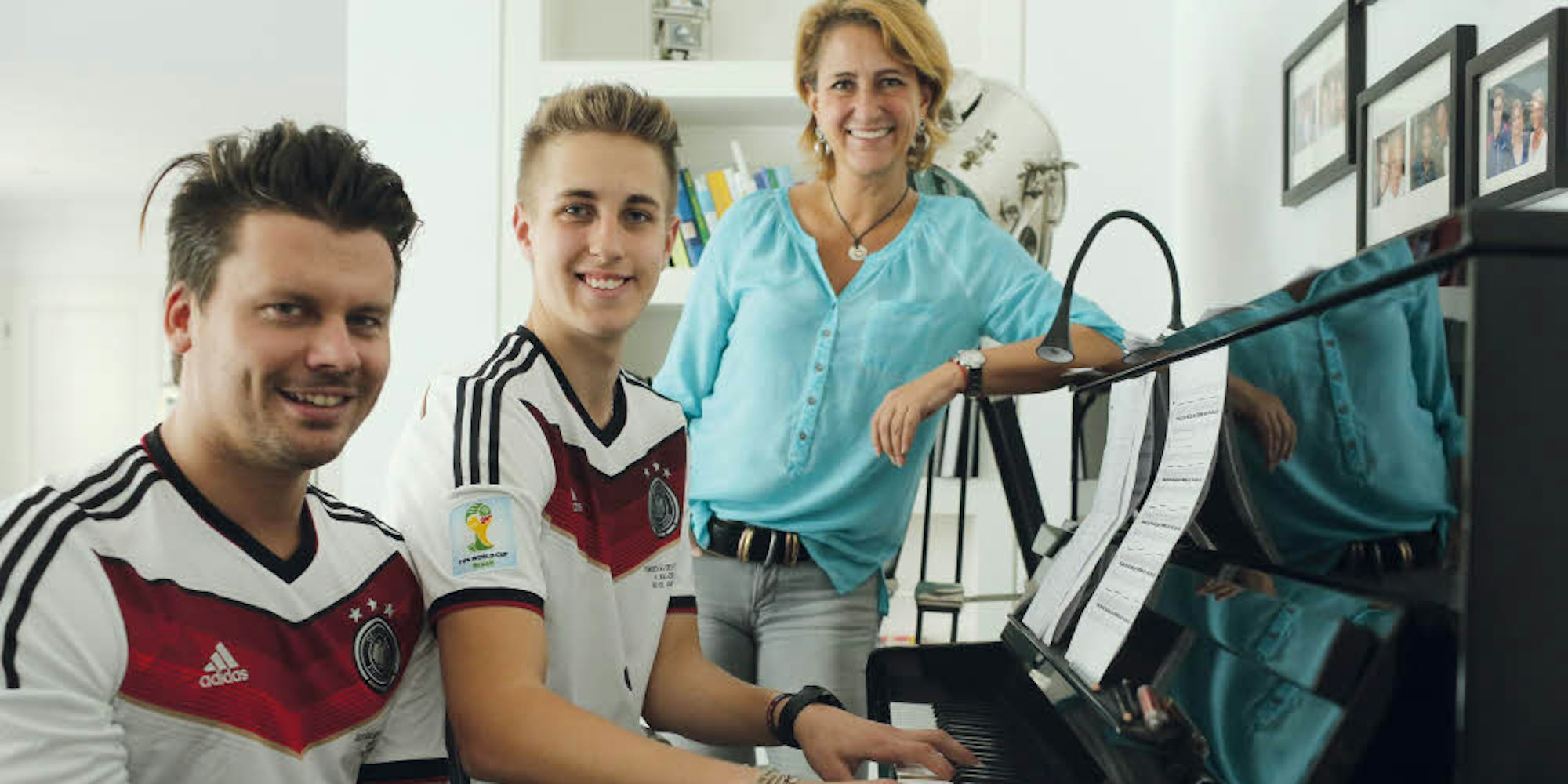 Texter und Komponist Luca Schneider (M.) am Klavier mit Mutter Nicole Bierhoff und Sänger Darius Zander (l.)