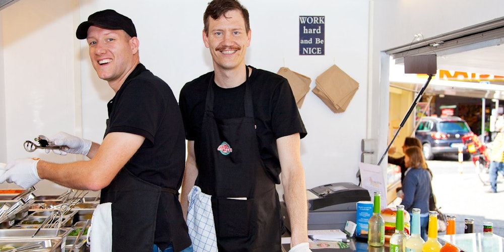 Die Gründer von Bunte Burger, Dr. Mario Binder und Ulrich Glemnitz, bei der Arbeit in ihrem Food Truck.