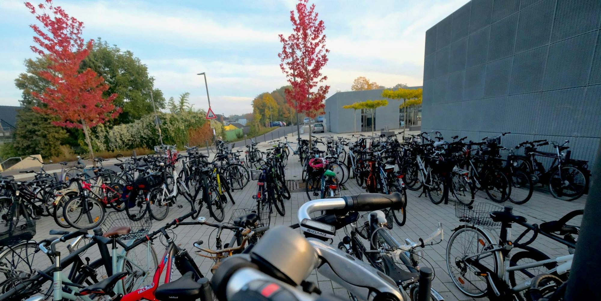 Nicht im Fahrrad-Parkhaus (hinten r.) stehen die meisten Räder, sondern an den Anlehnbügeln im Freien.
