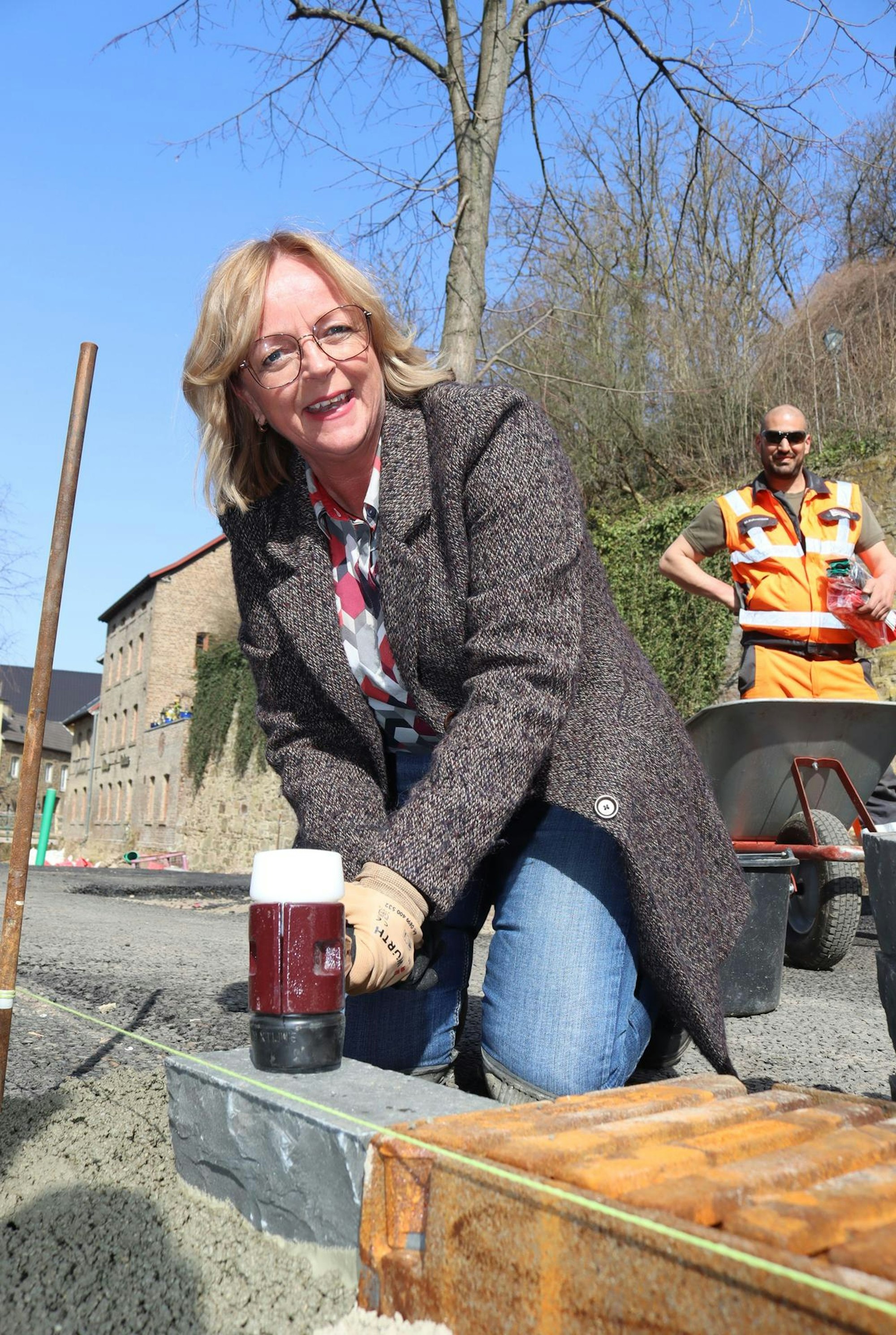 Der erste Pflasterstein liegt: Bürgermeisterin Sabine Preiser-Marian setzte den ersten Basaltstein auf dem Werther Platz. Ende Juni sollen die Arbeiten größtenteils abgeschlossen sein.