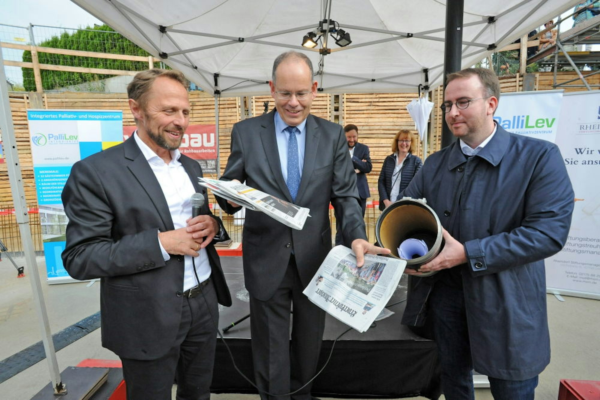 Uwe Richrath, Klaus Müller und Christoph Meyer zu Berstenhorst bestücken die Zeitkapsel mit Zeitungen und Dokumenten.