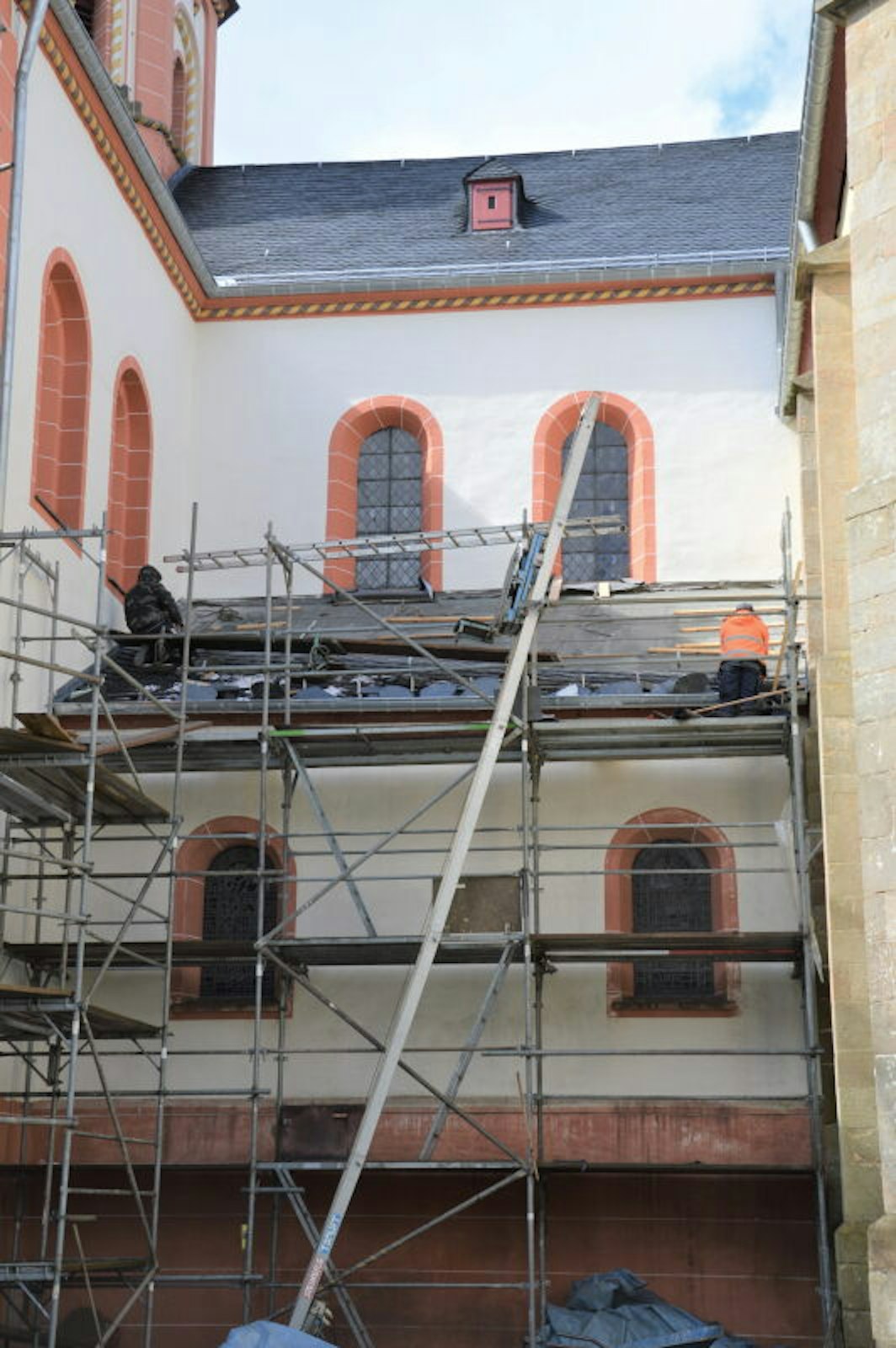 Oben ist die Fassade bereits neu gestrichen. Der untere Teil kommt erst dran, wenn das Dach dazwischen neu gedeckt ist.
