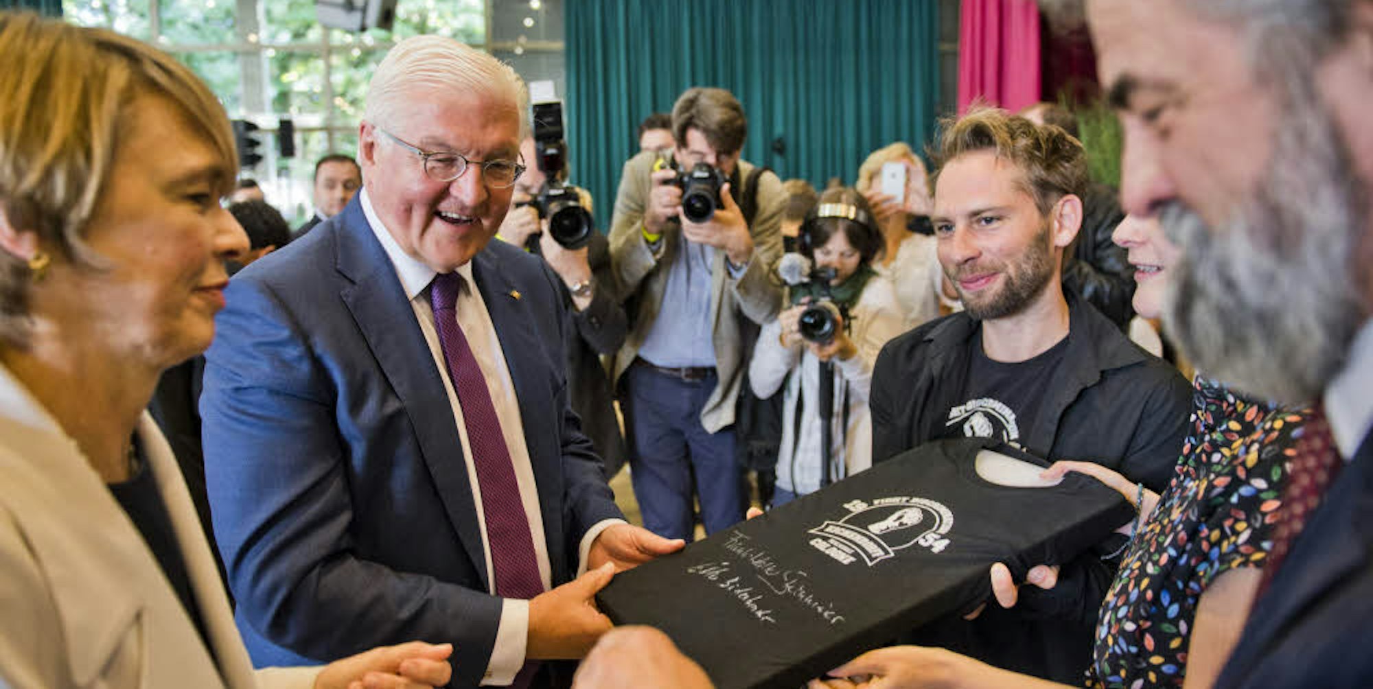 Ein T-Shirt überreichten Schüler dem Bundespräsidenten und seiner Lebensgefährtin Elke Büdenbender.