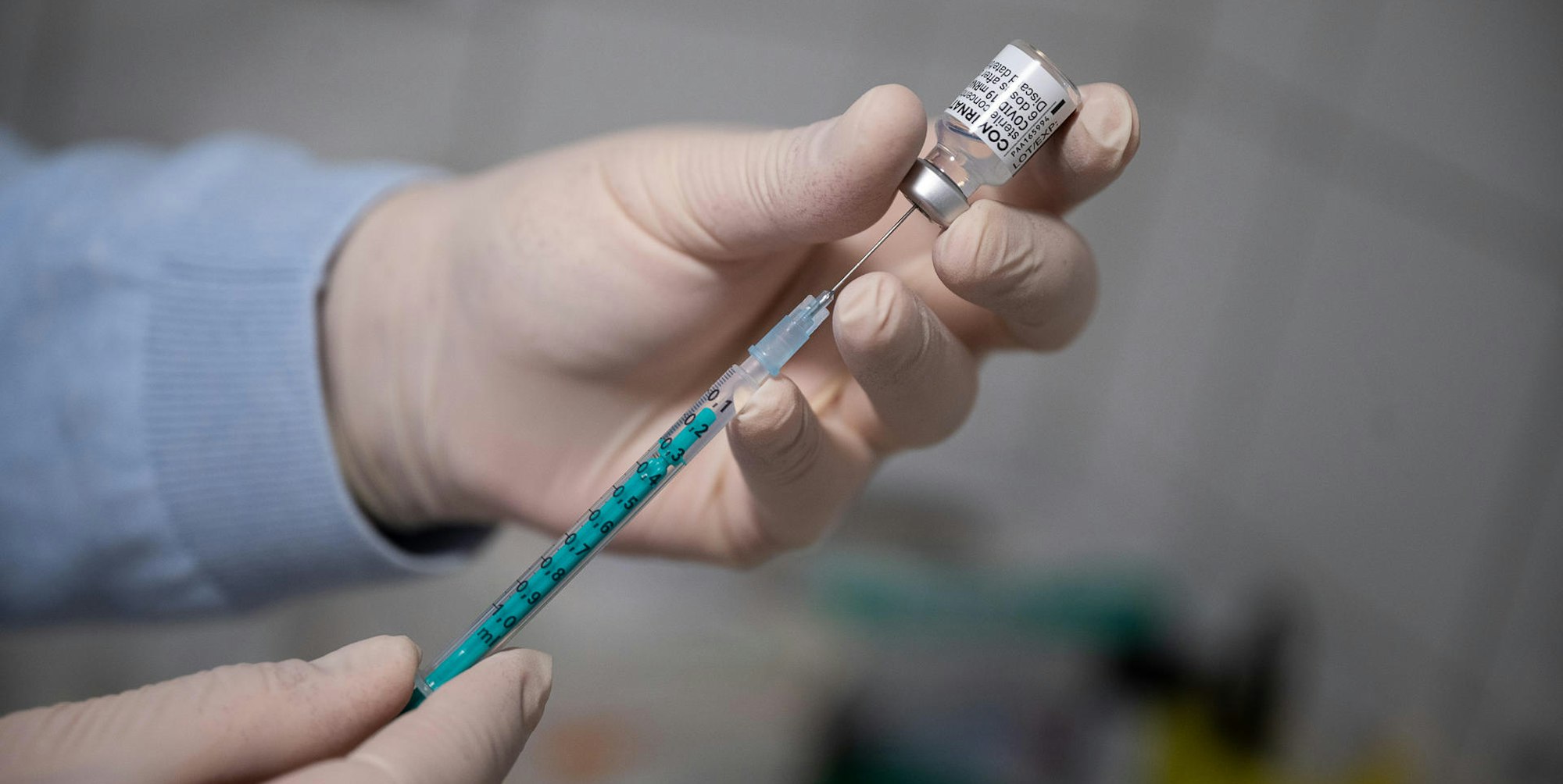 Arzt füllt Spritze mit Impfstoff