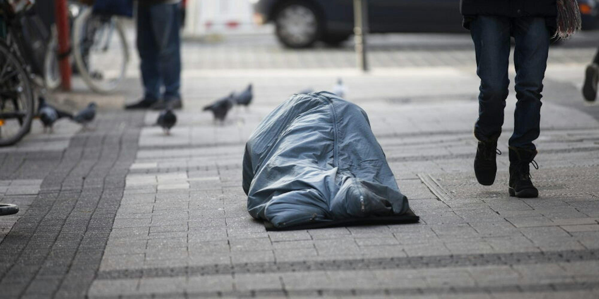 Hilfe bitter nötig: Ein obdachloser Menschen liegt tagsüber in der Fußgängerzone.