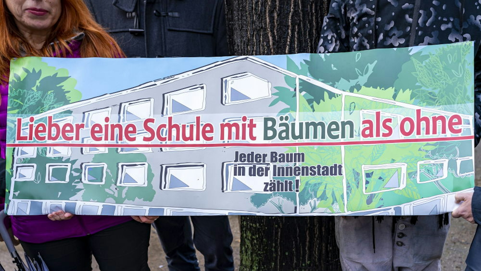 Mit Plakaten macht die Anwohner-Initiative auf die geplante Fällung von Bäumen zugunsten des Schulausbaus aufmerksam.
