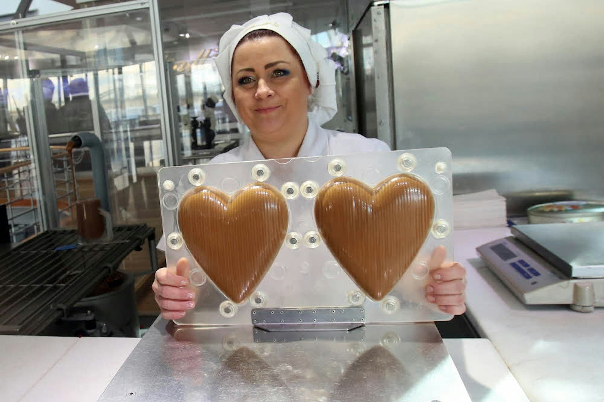 Diese Herzen werden erst befüllt und dann stundenlang in einer Maschine gewendet, damit sich die Schokolade am Rand gleichmäßig absetzt.