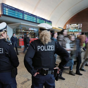 Polizistinnen kontrollieren im Kölner Hauptbahnhof Menschen.