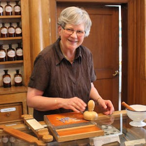 Führung durch die alte Schwanen-Apotheke: Die ehemalige Inhaberin Gertrudis Symann zeigt, wie Pillen und Zäpfchen selbst hergestellt wurden.