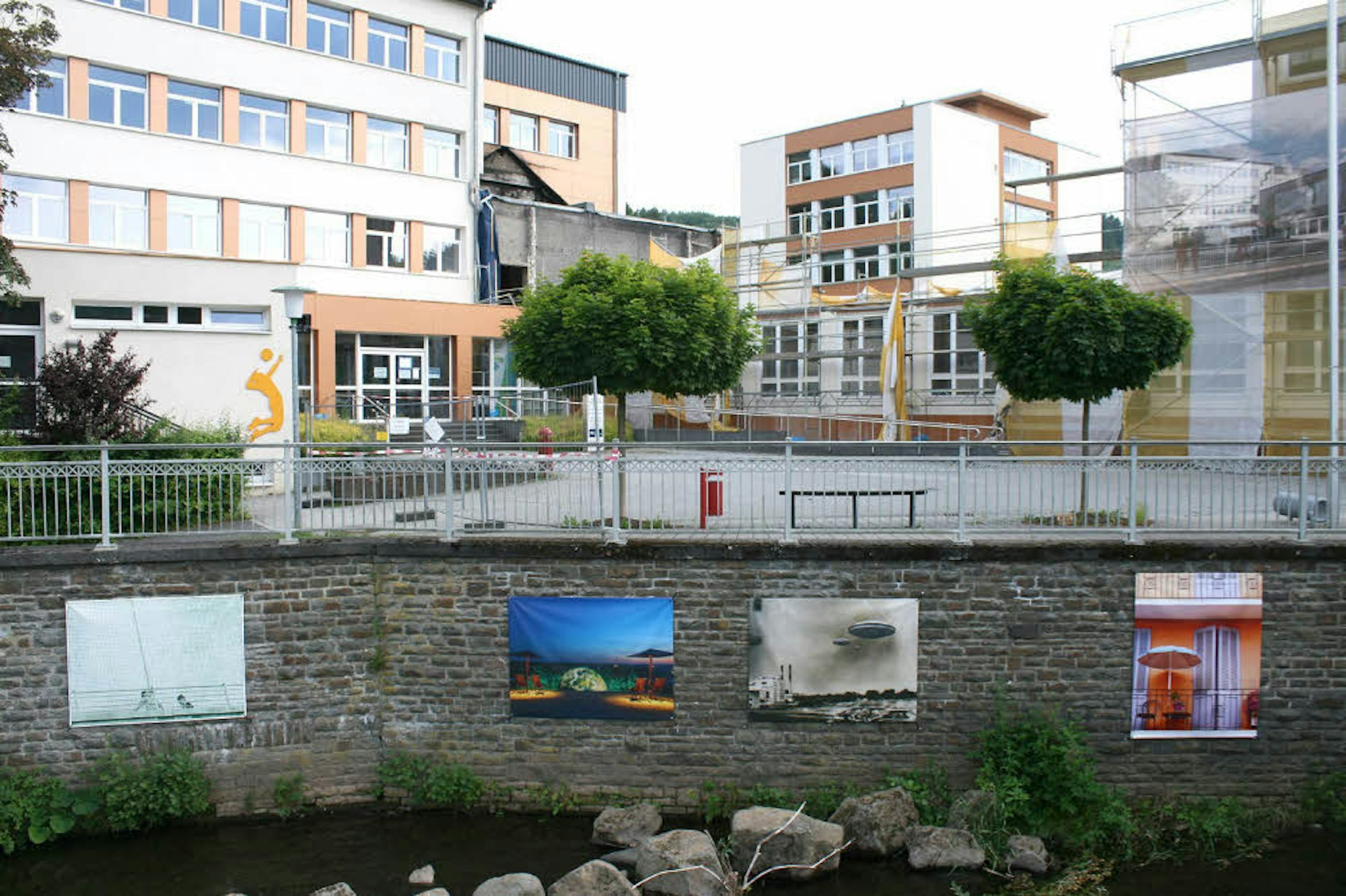 Auch in Schleiden, wie hier an der Mauer am Sturmius-Gymnasium, ist „Kunst im Fluss“ zu sehen.