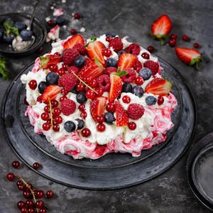 Pavlova-Torte mit Erdbeeren, Himbeeren, Johannisbeeren und Blaubeeren