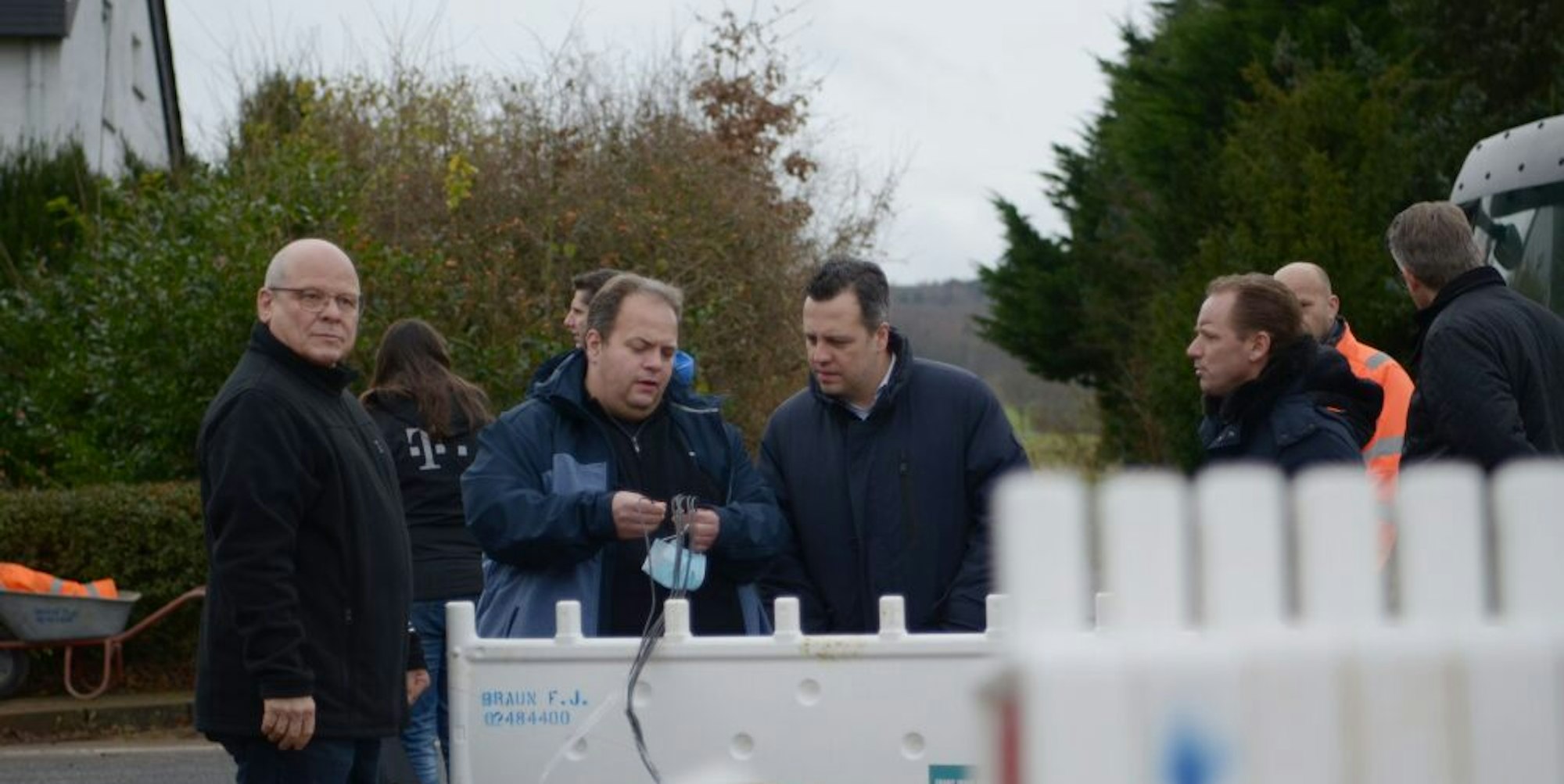 Der Bauleiter der Telekom, Ralf Waters (2.v.l.), zeigt Bürgermeister Sacha Reichelt das Glasfaserkabel.