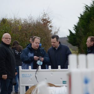 Der Bauleiter der Telekom, Ralf Waters (2.v.l.), zeigt Bürgermeister Sacha Reichelt das Glasfaserkabel.