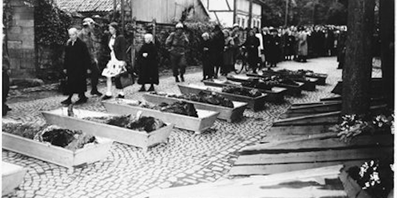 Einwohner Lindlars müssen an den geöffneten Särgen der ermordeten Kriegsgefangenen vorbeilaufen.